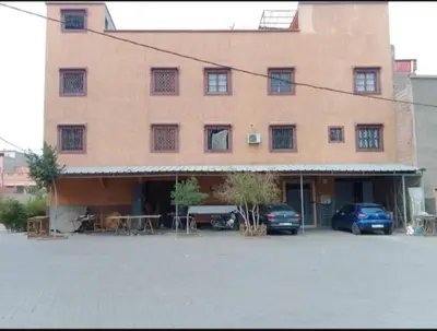 a large building with cars parked in front of it at Marrakech autrement in Marrakech