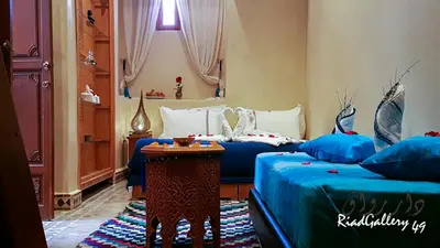 a hotel room with two beds and a table at Riad Gallery 49 & Spa in Marrakech