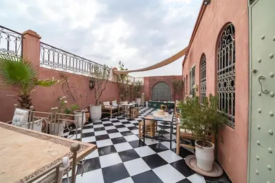 an outdoor patio with a black and white checkered floor at Riad Appart Arwa in Marrakech