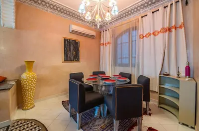 a dining room with a table and chairs and a chandelier at Riad Appart Arwa in Marrakech