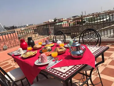 a table with food and orange juice on a balcony at Riad Dar Attika in Marrakech
