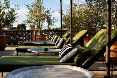 a row of green chairs and tables on a patio at Sakkan in Marrakech