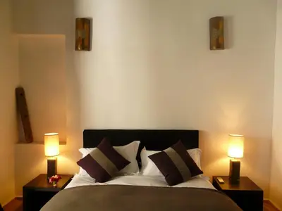 a bedroom with a bed with two night stands and two lamps at Maison Manzano in Marrakech