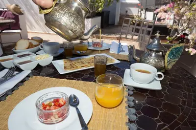 a table with breakfast foods and a pitcher of orange juice at Maison Manzano in Marrakech