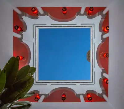 a mirror with red lights on a wall at Maison Manzano in Marrakech