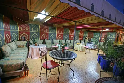 a living room with a couch and tables and chairs at Riad Taghazoute in Marrakech
