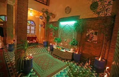 a living room with plants and a brick wall with a fireplace at Riad Taghazoute in Marrakech