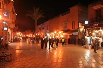 a group of people walking down a street at night at Riad Taghazoute in Marrakech