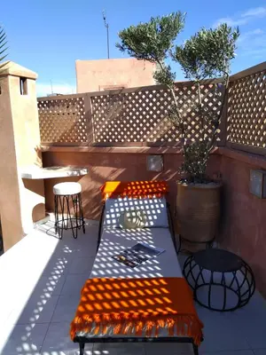 a patio with a table and chairs on a balcony at Riad BILKIS in Marrakech