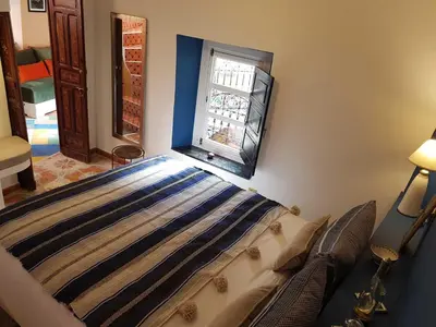a bedroom with a bed and a window at Riad BILKIS in Marrakech