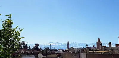 a view of a city with mountains in the background at Riad BILKIS in Marrakech