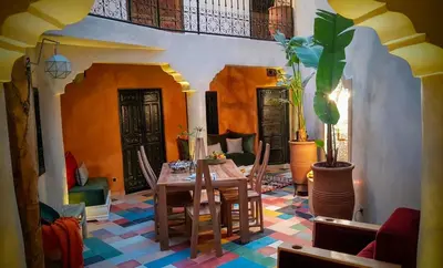 a living room with a table and a potted plant at Riad BILKIS in Marrakech