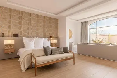 a bedroom with a bed and a couch and a window at Ksar Char-Bagh Small Luxury Hotels in Marrakech
