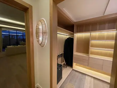 a walk in closet with wooden cabinets and a fan at Ksar Char-Bagh Small Luxury Hotels in Marrakech