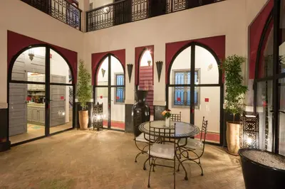 a room with a table and chairs in a building at Riad Alegria in Marrakech
