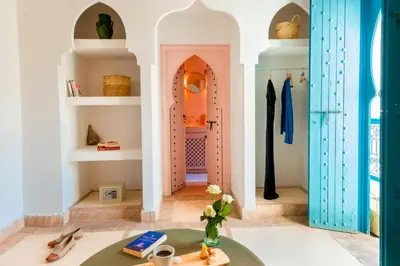 a room with a table with a vase of flowers at Riad Chamali in Marrakech