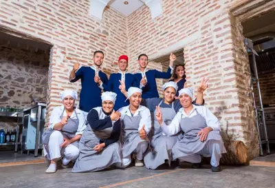 a group of people posing in front of a brick wall at Riad Chamali in Marrakech