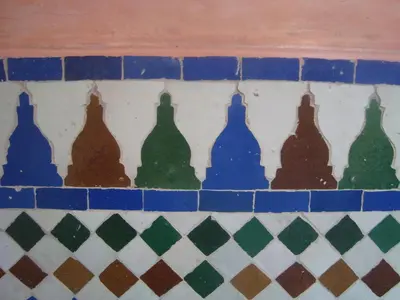 a group of glass bottles on a tile wall at Riad Jnane Mogador in Marrakech