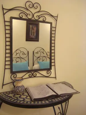a mirror on top of a table with a book at Riad Jnane Mogador in Marrakech
