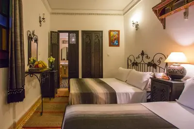 a hotel room with two beds and a mirror at Riad Jnane Mogador in Marrakech
