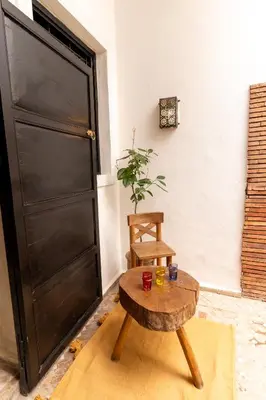 a room with a table and a chair and a door at Riad Shambala in Marrakech