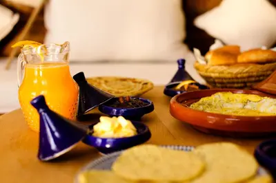 a table with food and a glass of orange juice at Riad Shambala in Marrakech