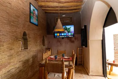 a dining room with a table and a tv at Riad Shambala in Marrakech