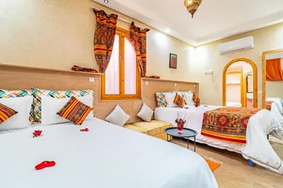 a hotel room with two beds and a couch at Maison KA in Marrakech