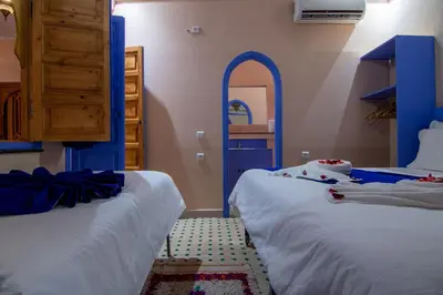 a room with two beds and a blue door at Maison KA in Marrakech