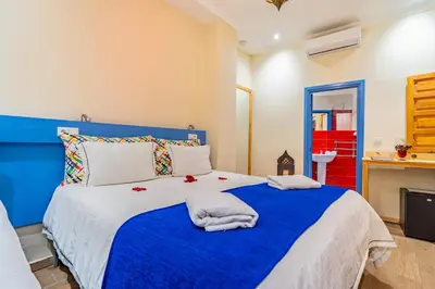 a bedroom with a blue and white bed with towels on it at Maison KA in Marrakech
