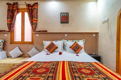 a bedroom with a large bed with a colorful blanket at Maison KA in Marrakech