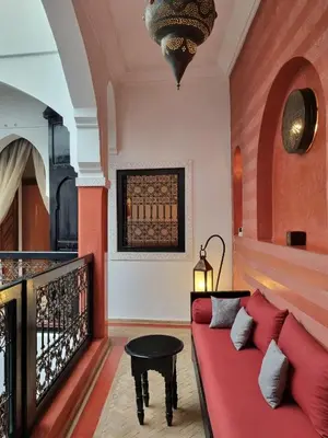 a living room with a red couch and a table at Riad les Rêves d'Amélie in Marrakech