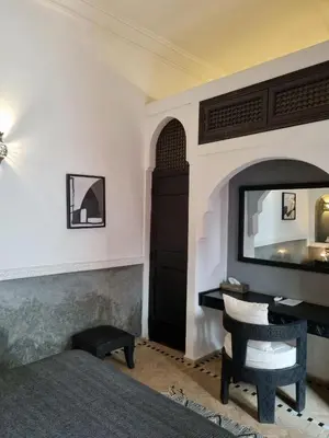 a bedroom with a bed and a mirror on the wall at Riad les Rêves d'Amélie in Marrakech