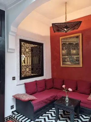 a living room with a red couch and a table at Riad les Rêves d'Amélie in Marrakech