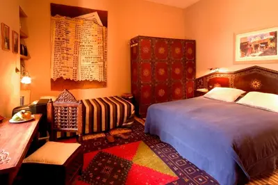 a bedroom with a bed and a table and a chair at Riad Noga in Marrakech