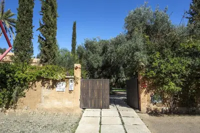 a wooden gate in a driveway with trees in the background at Villa Atlas de Luxe avec piscine privée Domaine des Kasbahs in Marrakech