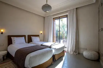 two beds in a hotel room with a window at Villa Atlas de Luxe avec piscine privée Domaine des Kasbahs in Marrakech