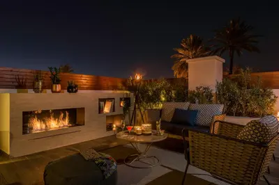 a patio with a fireplace and a couch and a table at La Brillante Marrakech in Marrakech