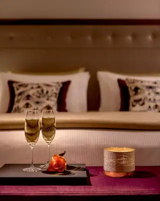 two glasses of wine on a table next to a bed at La Brillante Marrakech in Marrakech