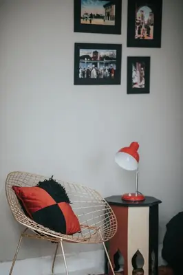 a room with a chair with a red pillow on it at Dar Titrit in Marrakech