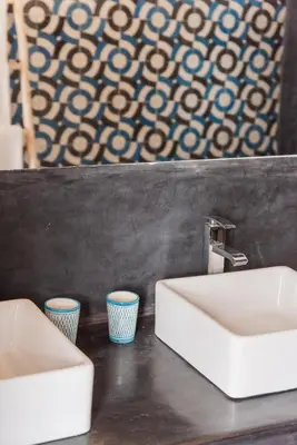 a bathroom with two sinks and two cups on a counter at Dar Titrit in Marrakech