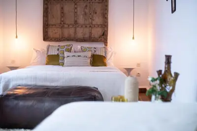 a bedroom with a large bed with a wooden headboard at Dar Titrit in Marrakech