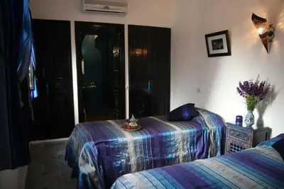 a bedroom with a bed with a blue comforter at Riad Dar Zampa in Marrakech