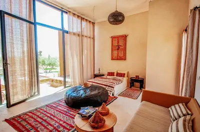 a bedroom with a bed and a large window at SA FONDA in Tameslouht