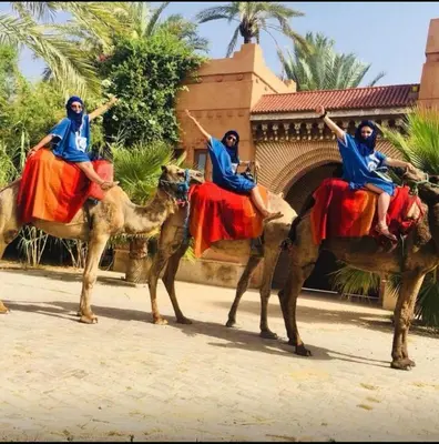 three people riding on the backs of camels at Riad Maison Aicha in Marrakech