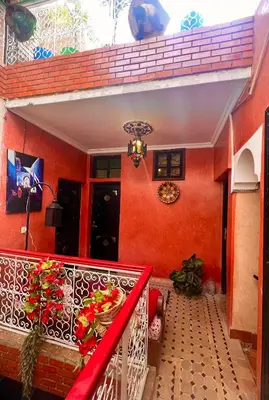 a balcony of a house with a red wall at Riad Maison Aicha in Marrakech