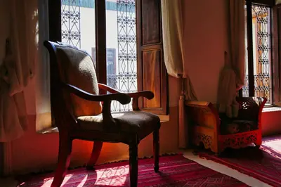 a chair sitting in a room with a window at Riad du Ciel Marrakech in Marrakech