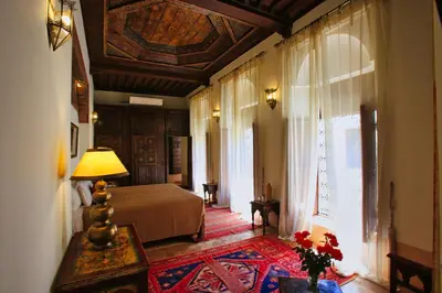 a bedroom with a bed and a table with a lamp at Riad du Ciel Marrakech in Marrakech