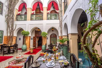 a dining room with tables and chairs in a building at Riad Anabel in Marrakech