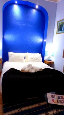a bed with a blue headboard in a room at Riad Rêve d Antan in Marrakech